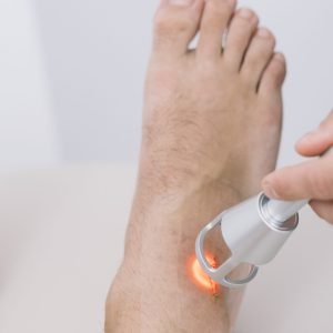 The physiotherapist treating a man using equipment for Lightning Laser